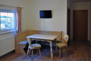 a dining room table with two chairs and a television at Popp`n Angerl in Tauplitz