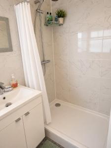 a bathroom with a white tub and a sink at Planet 9 in Warrington