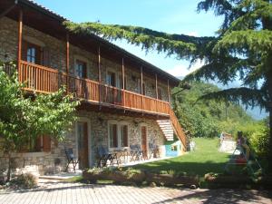 a stone house with a balcony and a yard at Agritur Maso Talpina in Mori
