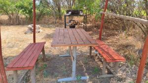 a picnic table and two benches and a grill at Levendula Vendégház in Ács
