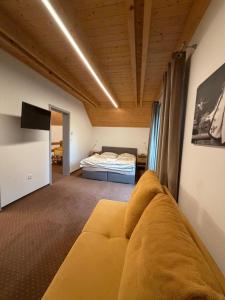 a living room with a couch and a bed at Chata ŠENKÁRKA Zuberec in Zuberec