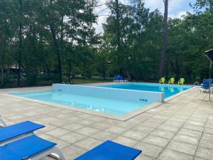 a swimming pool with people in yellow jackets standing around it at Fre&dom in Lacanau