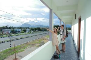 a man and a woman standing on the balcony of a building at Vetri Residency in Agastīswaram +5 photos