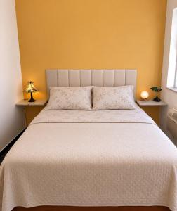 a bedroom with a large bed with a white bedspread at A Tóca in Rio de Janeiro