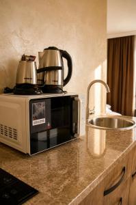 a kitchen counter with a microwave and a sink at VELOR Hotel apartment in Batumi