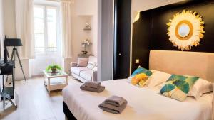 a bedroom with a large bed with towels on it at KosyKasa SPA in Cannes