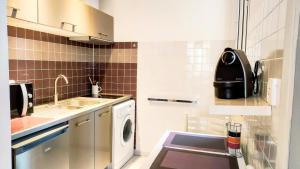 a small kitchen with a sink and a washing machine at KosyKasa SPA in Cannes