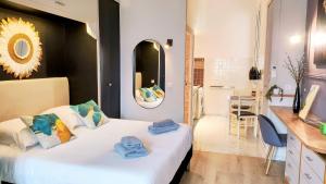 a bedroom with a white bed with a mirror and a bathroom at KosyKasa SPA in Cannes