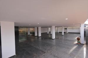 an empty building with white columns and a lobby at Hotel Vibrama in Tirupati