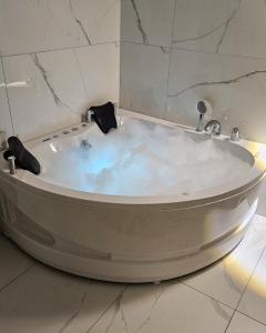 a white bath tub in a bathroom with marble walls at Vikendica 937 Lux & Spa, Istočno Sarajevo, Pale, Jahorina i Sarajevo na 15km in Pale