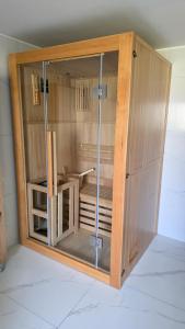 a wooden cabinet with glass doors in a room at Vikendica 937 Lux & Spa, Istočno Sarajevo, Pale, Jahorina i Sarajevo na 15km in Pale