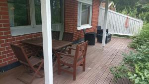 a deck with a wooden table and chairs on a house at Half Way in Kalaniemi