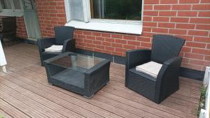 two wicker chairs and a glass table on a deck at Half Way in Kalaniemi +3 photos