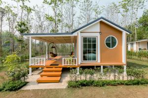 a tiny house with a porch and a deck at ศรีคำน่านรีสอร์ท in Ban Muang Chang Tai