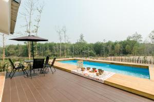 a deck with a table and chairs next to a pool at ศรีคำน่านรีสอร์ท in Ban Muang Chang Tai