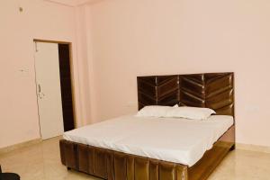 a bed with a leather headboard in a room at Nirvana Homestay in Chamba