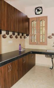 a kitchen with wooden cabinets and a sink at Nirvana Homestay in Chamba