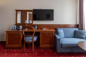 a hotel room with a desk and a chair and a tv at Hotel Diamond w Białym Dworku in Rumia