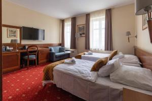 a hotel room with a large bed and a desk at Hotel Diamond w Białym Dworku in Rumia