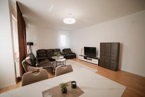a living room with a couch and a tv at Estilo Apartments in Prishtinë