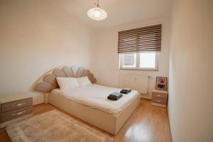 a small bedroom with a bed and a window at Estilo Apartments in Prishtinë