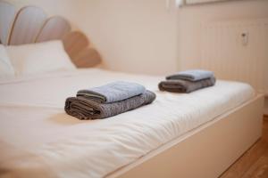 two towels sitting on top of a white bed at Estilo Apartments in Prishtinë +16 photos