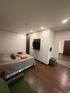 ein Schlafzimmer mit Bett und Flachbildfernseher in der Unterkunft Tufenkian Old Dilijan Complex in Dilidschan