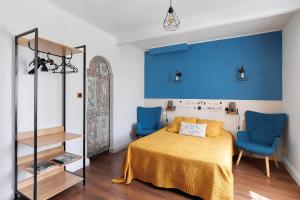 a bedroom with a bed and two blue chairs at Lorali - Chambre d'Hôtes in Gohier