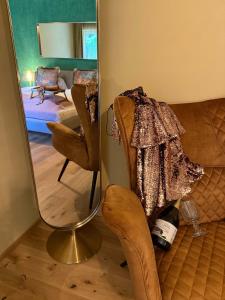 a living room with a chair and a mirror at Newly renovated Boutique Hotel Giulia Slow Residence in Velden am Wörthersee