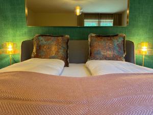a bedroom with a bed with two pillows and a mirror at Newly renovated Boutique Hotel Giulia Slow Residence in Velden am Wörthersee +72 photos