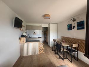 a living room and kitchen with a table and chairs at Refuge 1000, studio cosy in Mijoux