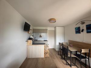 a kitchen and dining room with a table and chairs at Refuge 1000, studio cosy in Mijoux