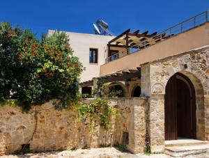 a house with flowers on the side of a wall at Villa Argiro Plaka Crete in Plaka