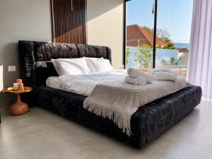 a black bed in a bedroom with a large window at סוויטת דיאנס - סוויטה רומנטית עם בריכה וג'קוזי ספא לזוגות in Gita +9 photos