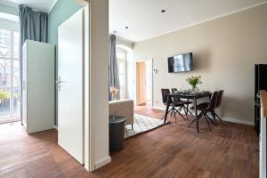 a living room with a table and a dining room at Central Apartment - Linienstraße in Berlin