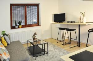 a living room with a couch and a table at Centrum Comfort Apartment in Rimavská Sobota