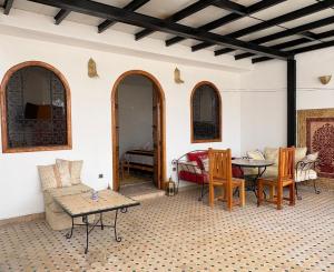 a living room with a couch and a table and chairs at Riad Fes Colors & SPA - Family Lodging in Fez