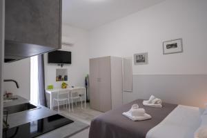 a white room with a bed and a kitchen at L'angolo del viaggiatore in Nicosia