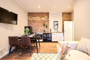 a living room with a dining room table and a kitchen at Central Apartment - Linienstraße in Berlin