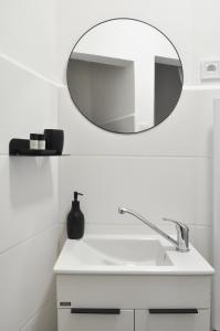 a bathroom with a white sink and a mirror at Centrum Comfort Apartment in Rimavská Sobota +6 photos