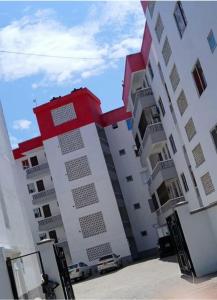 a large white building with a red chair on it at Asante Studio in Mtwapa