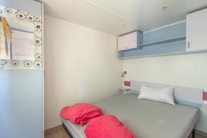 a small room with a bed and blue cabinets at Móvil Home Grande in Alós de Balaguer
