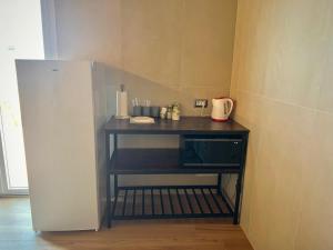 a kitchen with a table with a microwave and a refrigerator at Casa Romano SeaFront in Fiumicino