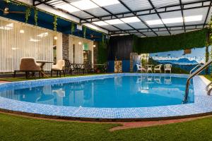 a large pool with a table and chairs next to it at Lotus Villa in Phuntsholing