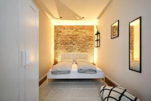 a bedroom with a bed and a brick wall at Central Apartment - Linienstraße in Berlin