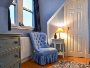 a blue chair in a room with a table and a lamp at Vindolanda in Fearnmore +13 photos