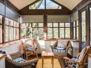 a living room with chairs and windows at Riverbank Cottage-Uk42229 in Low Borrowbridge