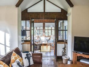 a living room with a couch and a tv at Riverbank Cottage-Uk42229 in Low Borrowbridge