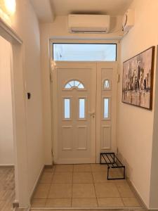 a hallway with a white door with a window at Modern Cozy Apartment Lola in Doboj