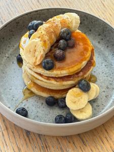 a plate of pancakes with blueberries and bananas at Margarita Fresh Studios in Potos +53 photos